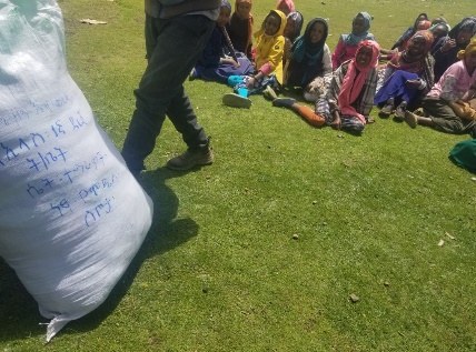 Delivering a sack of sanitary pads to a school